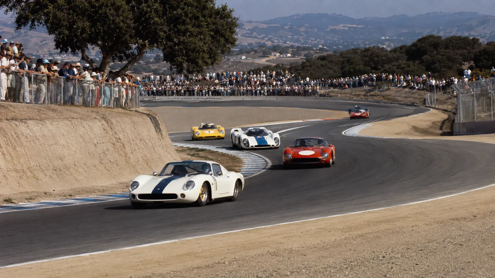 Autos de carreras japoneses históricos conceptuales recorren un circuito de California ante el público.